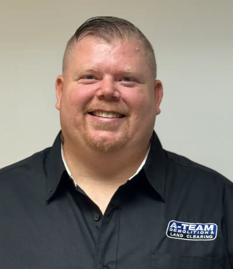 A smiling man in a black button-up and an A-Team shirt.
